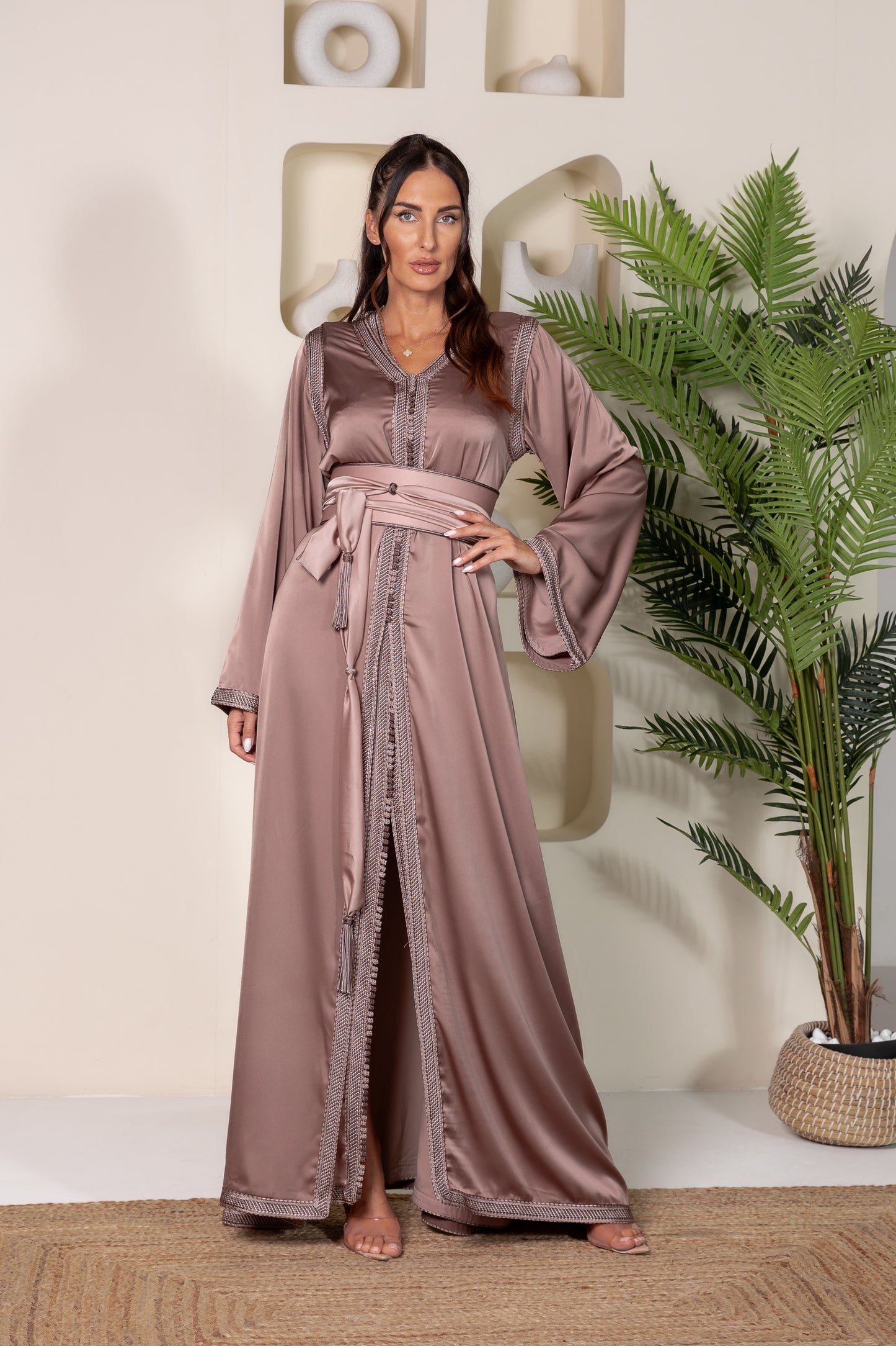 Woman in bronze Moroccan kaftan with wide sleeves and a matching belt