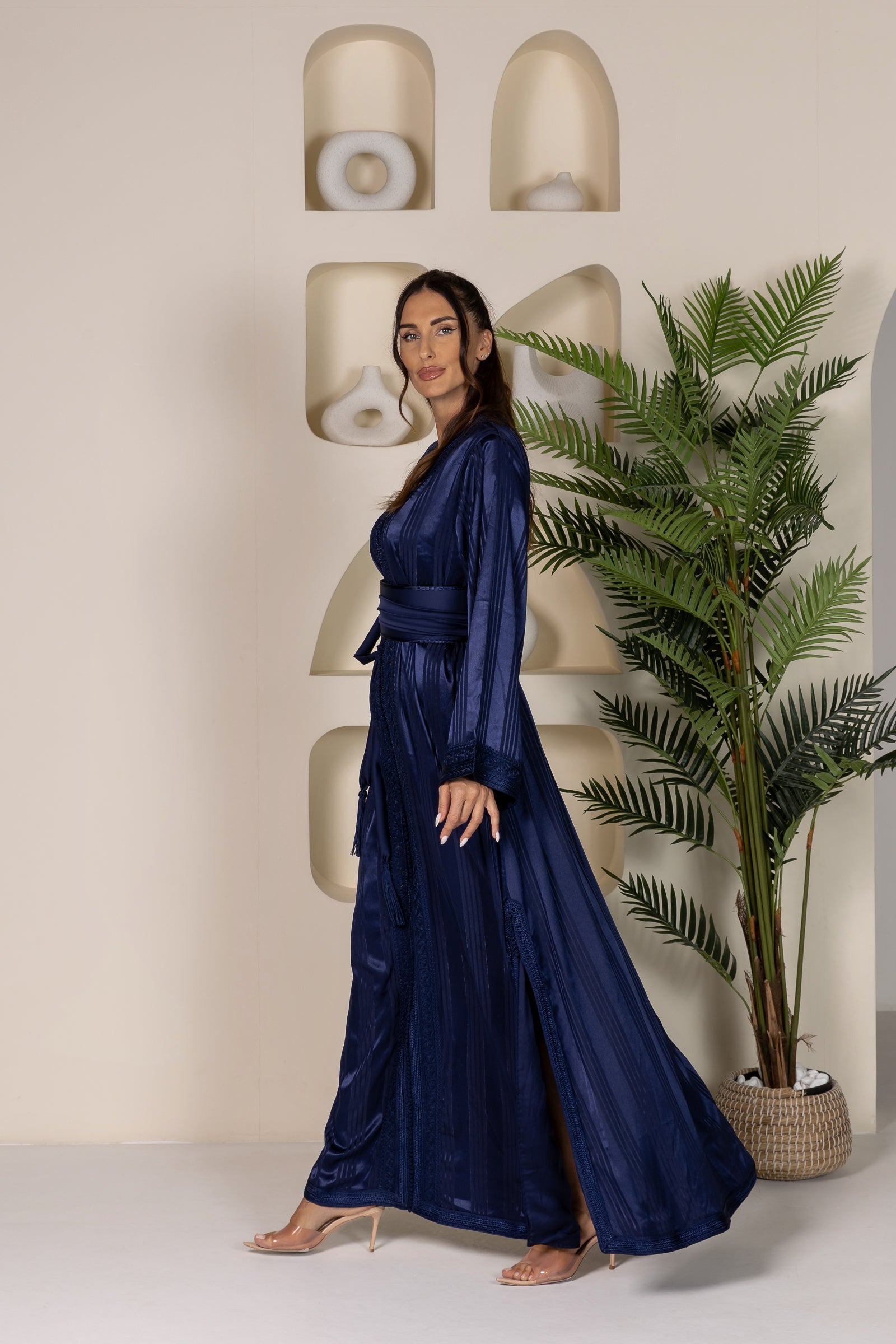 Side view of woman in dark blue Moroccan kaftan with slit