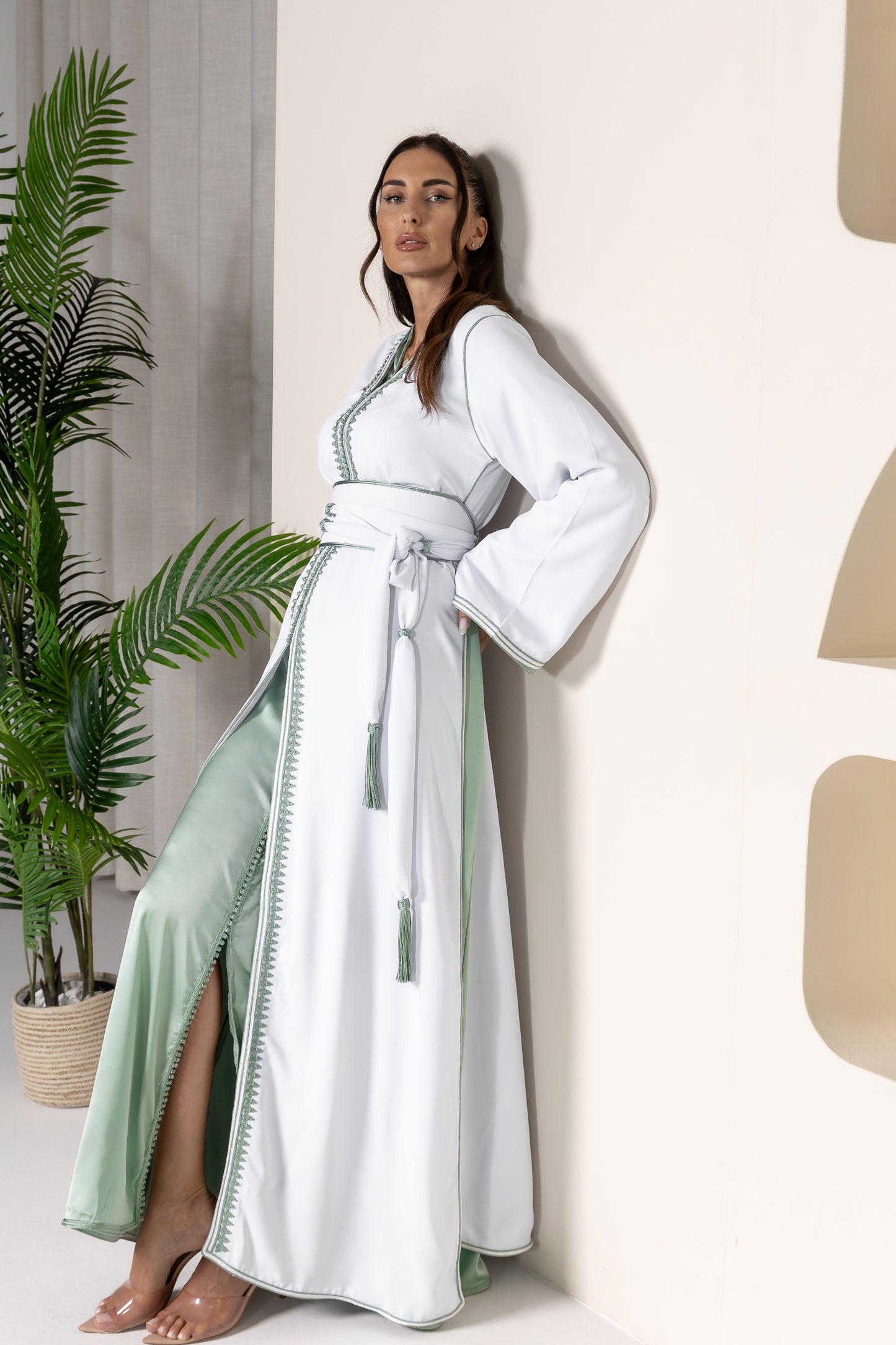 Side view of white Moroccan kaftan revealing green-lined sleeves