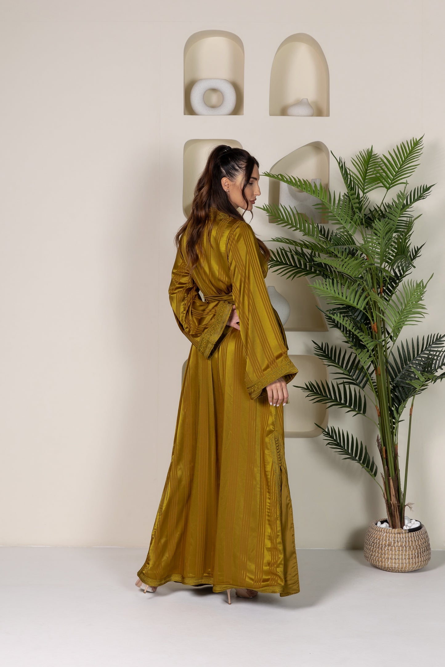 Back view of a mustard yellow Moroccan kaftan with elegant fabric drape